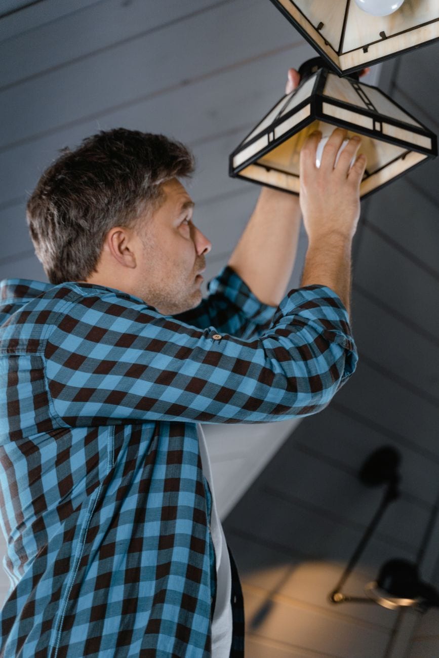 Electrician installing a ceiling light fixture